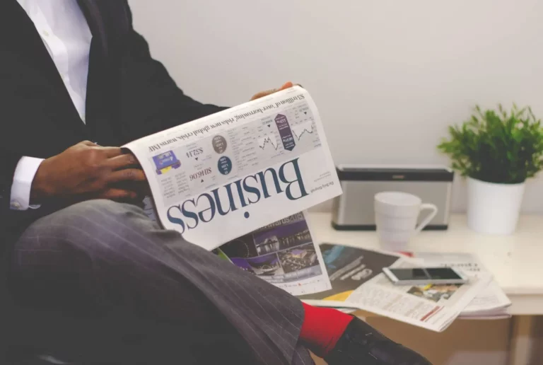 a person reading a newspaper about business trends